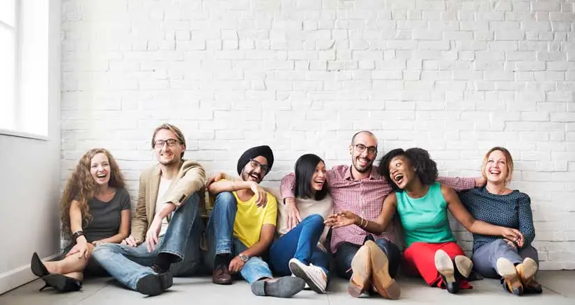 An image of a group of friends from diverse backgrounds sitting together